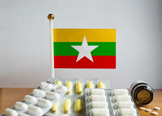 Flag of Myanmar with Pills and Capsules. Pharmaceutical Concept
