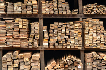 Pile of weathered wooden planks, stacked high and ready for use in construction or carpentry....