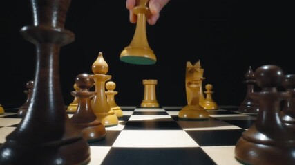 Player hand moving white queen chess piece on a chessboard