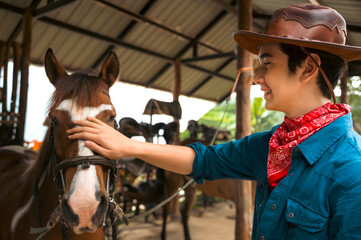 Attractive cowboy touching horse face in wild west ranch