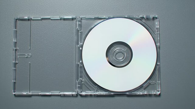White Compact Disc in Clear Plastic Case on a Gray Surface Top View