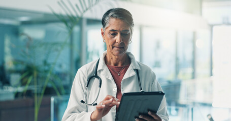 Fototapeta premium Mature woman, doctor and tablet for research, telehealth or check email in clinic. Medical professional, technology and reading report for healthcare records, online schedule or test results with app