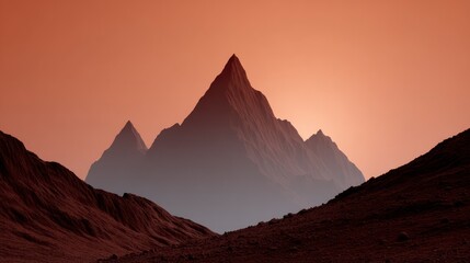 Naklejka premium Jagged mountain peaks rise from a rocky arid terrain under a soft orange sky