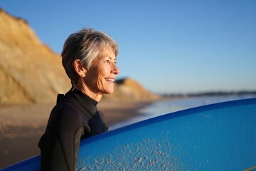 Senior woman surfing active lifestyle enjoying the beach waves and ocean outdoors today