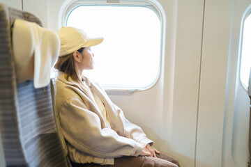 young asian woman sitting on the express train near the window. Tourist Enjoying and traveling by...