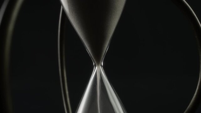 Abstract shot of vintage hourglass with white sand rotating - Powered by Adobe