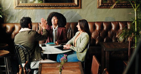 Meeting, high five and business people in coffee shop for discussion on proofreading for publishing. Happy, celebration and female editors with author for book research success in restaurant or cafe.