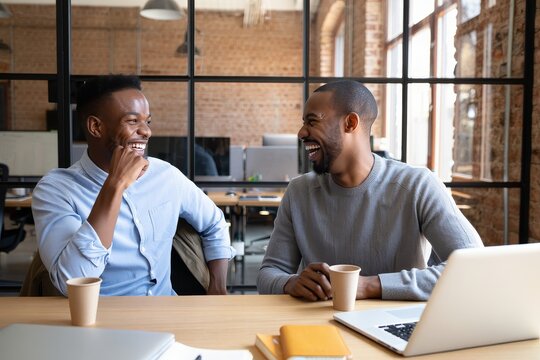 Two african american business men laughing in modern office workplace teamwork - Powered by Adobe