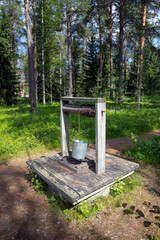 water well with broken metal bucket in the woods