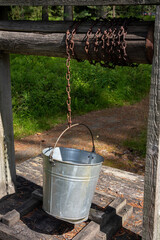water well with broken metal bucket in the woods