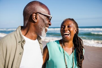 Happy senior african american couple laughing on beach vacation travel lifestyle fun