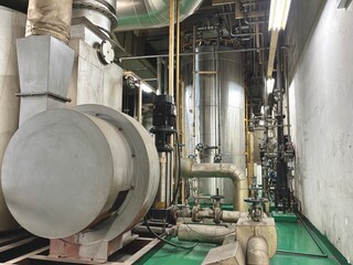  Industrial boiler room with stainless steel tanks, pipelines, valves, and ventilation system....