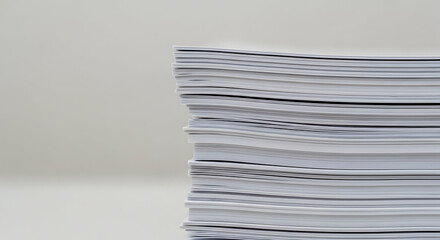 Stack of neatly arranged white papers on a plain background representing office work documentation and administrative tasks in a professional setting