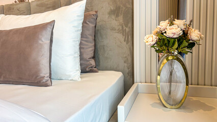 Modern Bedroom Interior With Bed, Pillows, And Decorative Vase With Flowers On Nightstand, Home Design Concept, Suitable For Real Estate, Hotel Promotion, Interior Decoration, Lifestyle, And Commercia