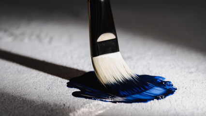  A paintbrush immersed in vibrant blue paint, creating a dynamic splash and drip effect against a clean white background.