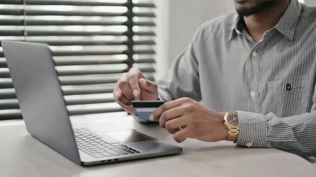 Customer inputting credit card data into laptop for online transaction process