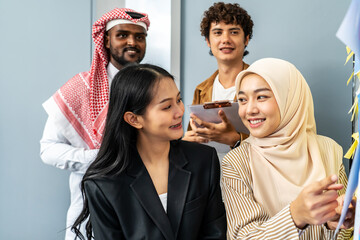 Diverse business team collaborating on project planning with charts and sticky notes on whiteboard, teamwork and brainstorming session in office, young professionals in modern business environment
