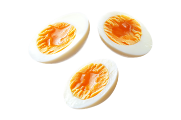 Three halved boiled eggs showing runny yolks isolated isolated on white or transparent png.