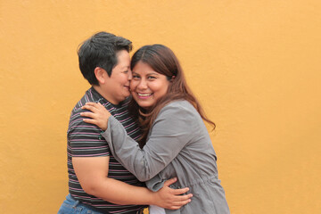 Two dark-skinned Latina lesbians are a couple and show their love with kisses and hugs to celebrate...