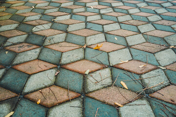 Weathered Geometric Paving Stones: An Optical Illusion Cube Pattern with Autumn Leaves
