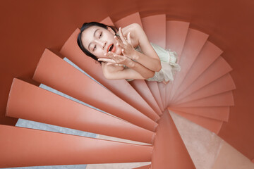 Teenage girl expressing joy on spiral staircase modern architecture inspirational scene aerial view