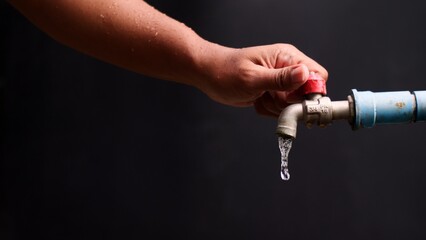 Water Conservation Gesture: A hand gracefully turns off a faucet, representing the importance of...