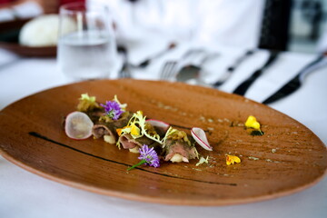 Elegant Beef Carpaccio Rolls with Microgreens, Radish, and Edible Flowers on Wooden Platter –...