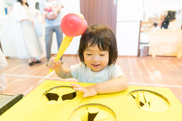 保育園でボーリングゲームで遊ぶ女の子の幼児