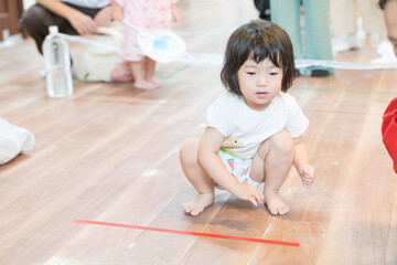 保育園でボーリングゲームで遊ぶ女の子の幼児