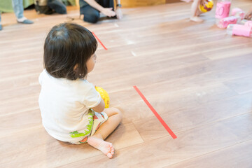 保育園でボーリングゲームで遊ぶ女の子の幼児