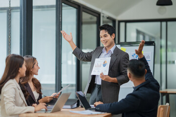 Group of business people are standing in a meeting presenting their work at the office.