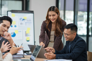 Group of business people are standing in a meeting presenting their work at the office.