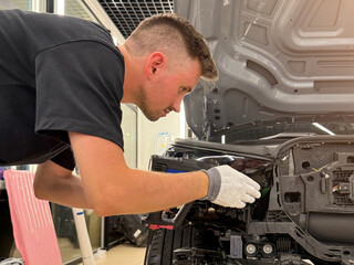 A car wrapping specialist applies a polyurethane film to the car. Detailer smoothes PPF. Car...