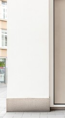 Clean, Modern Urban Building Facade with White Wall and Stone Base. Contemporary Architectural Detail on a City Street Pavement.