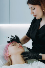  an aesthetic professional performing an injection procedure. Beauty treatment