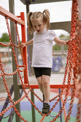 Fear of heights in children, a little girl climbing on the playground