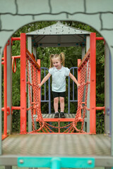Fear of heights in children, a little girl climbing on the playground