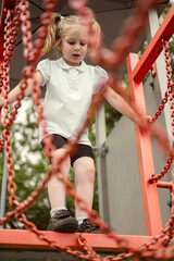 Fear of heights in children, a little girl climbing on the playground