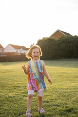 Happy little girl in the park at sunset