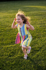 Little girl playing in the park at sunset