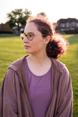 Teen age girl with purple curly hair and eyeglasses