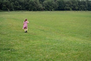 Little girl running in the park, copy space