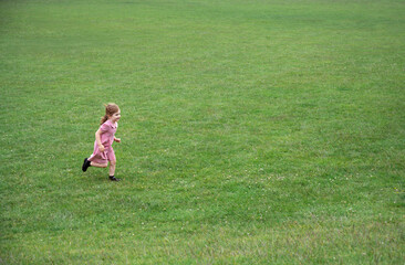 Little girl running in the park, copy space