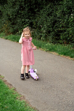 Little girl in the park with a scooter, werring school uniform