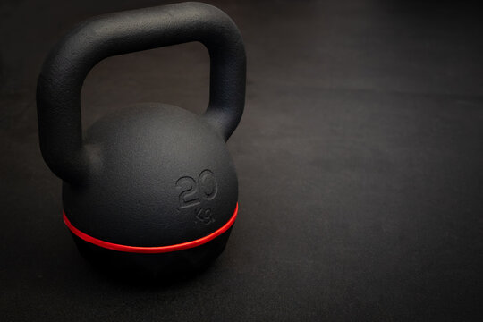 Black kettlebell on dark gym floor. Fitness and strength training