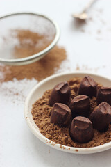 Truffle candies lie in a plate on a gray table