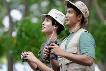 Bird watching is recreational pursuit. Young man and friend have fun with outdoors leisure activity...