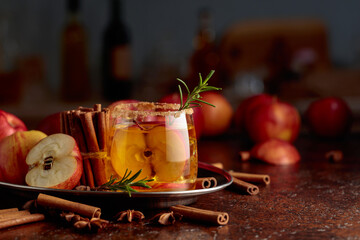 Apple cider with apple slices and a rosemary branch.