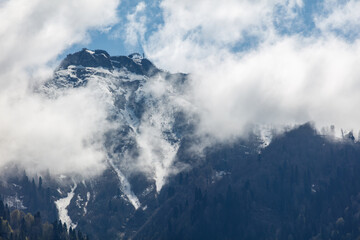 The mountain is covered in snow and the sky is cloudy