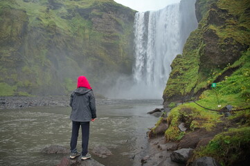 Senior woman standing in front of waterfall in Iceland